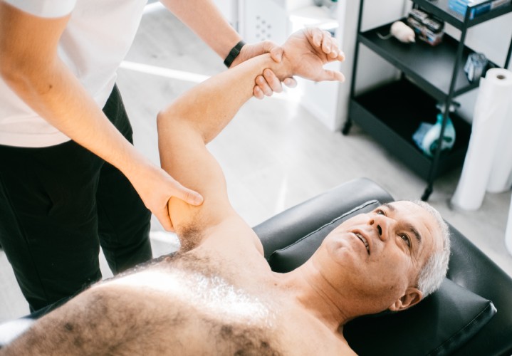 Fisioterapeuta ayudando a un paciente.