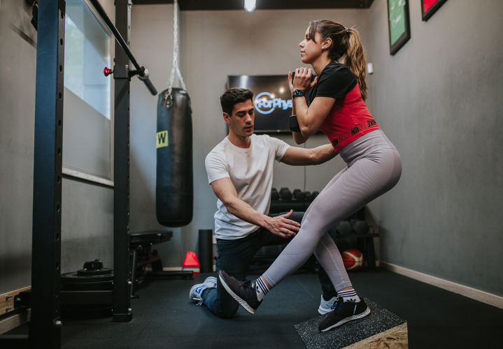 Image of a student performing an exercise with the assistance of a professional.