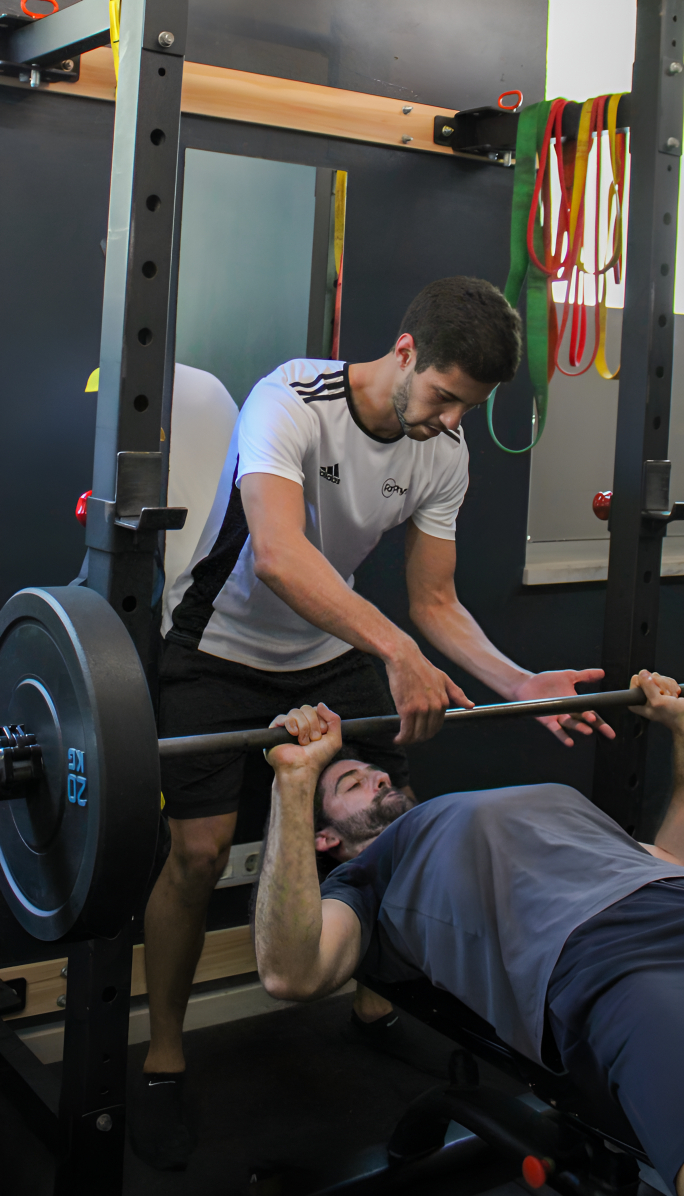 一名学生在专业人士的协助下进行锻炼的图片。